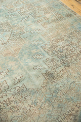 Faded sea foam blue and antique ivory geometric patterns on a distressed Heriz carpet.