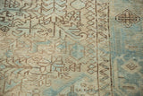 Distressed vintage Heriz rug close-up: softened geometric motifs in beige and seafoam blue.