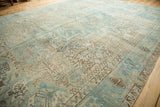 Faded seafoam green and coffee brown geometric patterns on a distressed vintage Heriz carpet.