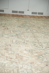 Distressed Heriz rug showing muted beige, sand, and sea foam geometric patterns.