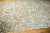 Distressed Persian Heriz rug border with muted sea foam and sand rectilinear patterns.