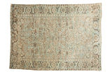 Distressed Heriz carpet with faded ivory, seafoam, and charcoal geometric floral pattern.