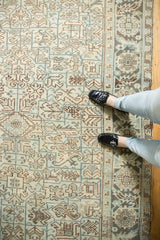 Distressed texture and pale sea foam green-blue geometric patterns on vintage Heriz rug, with feet.