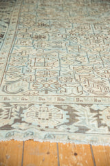Distressed texture of vintage Heriz carpet border featuring geometric motifs in pale sea foam.