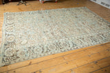 Distressed corner of vintage Heriz carpet, geometric lattice field, floral border in ivory, sea foam blue.