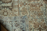Folded vintage Heriz carpet corner, revealing geometric patterns, distressed texture, and woven back.