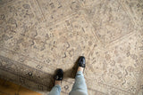 Decorative distressed vintage Shiraz rug, featuring faded ivory, brown geometric patterns.