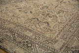 Detail of vintage distressed Shiraz carpet, geometric patterns, aged ivory, and visible foundation wear.