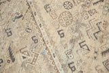 Distressed vintage Shiraz rug detail: geometric patterns, antique ivory, brown tones, visible wear.