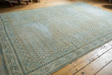 Vintage distressed Mir Arak carpet corner, displaying ivory and powder blue boteh design and knot head wear.