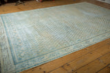 Distressed Mir Arak carpet with mostly even wear, ivory, beige, and powder blue boteh motifs.