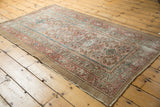 Distressed Hamadan rug corner with thick blush, sky blue borders, and low worn pile.