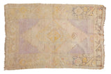 Distressed Vintage Oushak rug with faded lavender medallion, saffron vinery, and gray border.