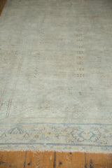 Distressed vintage Sivas rug's lower edge, featuring muted sky blue border design and fringe.