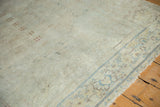 Distressed low pile ivory field with faint blue border of the vintage Sivas rug.