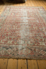 Distressed vintage Heriz carpet pile, faded cranberry red and denim blue geometric motifs.