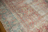 Distressed geometric Heriz carpet, revealing pale cranberry red, faded teal, and visible foundation.