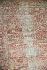 Distressed vintage Heriz rug texture, faded cranberry, pale blue geometric motifs, and visible foundation.