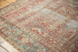 Distressed Vintage Heriz carpet pile showing faded cranberry, pale gold, and teal geometric motifs.
