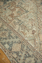 Mehrivan rug detail: distressed geometric field, serrated border in beige, teal, brown.