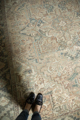 Faded beige, antique ivory, and dusty teal geometric patterns on a distressed Mehrivan carpet.