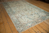Detail of vintage distressed Mehrivan carpet with geometric plant motifs, muted blush, teal, ivory, and foundation showing.