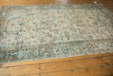 Distressed Mehrivan carpet's worn pile, showing geometric patterns and soft blue hues.