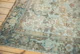 Distressed corner of the Mehrivan carpet, with muted blue, beige, and brown geometric motifs.