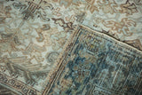 Folded distressed Mehrivan carpet reveals time-softened pile and hand-knotted foundation.