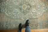Distressed Malayer carpet, low pile texture of ivory, teal, and gold geometric motifs.