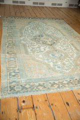Intricate geometric floral pattern and distressed texture on a vintage Malayer carpet.