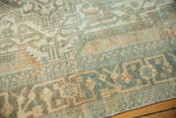 Distressed Malayer rug close-up: faded geometric patterns, low pile, visible white knots.