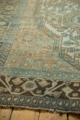 Vintage distressed Malayer carpet's geometric border with muted brown and soft teal.