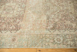 Distressed vintage Karaja rug with rectilinear floral motifs, muted blush, beige, and visible wear.
