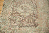 Distressed Karaja rug section showing faded geometric patterns, blush and beige colors.