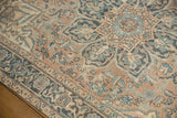 A distressed Ahar rug's low pile, showing a scalloped starburst medallion and floral border.
