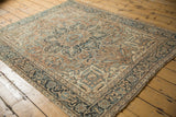 Angled view of a vintage Ahar rug, highlighting its starburst medallion and distressed low pile.