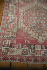 Distressed Serab runner border featuring geometric pawn motif, serrated medallion, pale red, ivory.