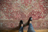 Distressed vintage Heriz carpet with even wear, faint foundation, and geometric floral designs.
