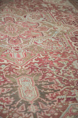 Decorative distressed pile of a vintage Heriz rug featuring raspberry, blush, and bronze florals.