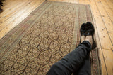 Vintage distressed Kurdish runner's allover plant motifs, showing faded colors and worn texture.