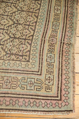 Distressed Kurdish runner corner with reciprocating pawn border and faded plant motifs.