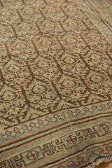Distressed charcoal Kurdish rug showcasing potted plant motifs and a Laleh Abassi border.