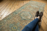 Distressed vintage Karaja runner, geometric floral pattern in dusty gold, powder blue, showing pile wear.