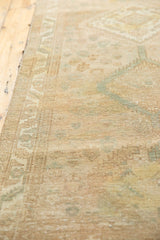 Distressed vintage Serab runner with even pile wear and soft beige, faded green geometric patterns.