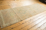 Textured distressed Serab runner displaying even wear, geometric motifs, and faded beige, sand, pale green.
