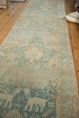 Close-up of faded teal and pale beige oversized animal motif on distressed Heriz runner.