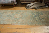 Distressed vintage Heriz runner with faded sea foam green and bronze medallion designs.