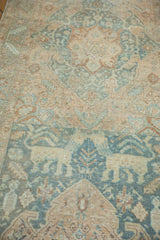 Distressed Heriz runner displaying oversized animal motifs in faded teal and ivory tones.