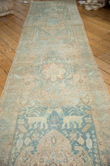 Distressed vintage Heriz runner featuring oversized mythical animals, faded teal, and visible foundation wear.